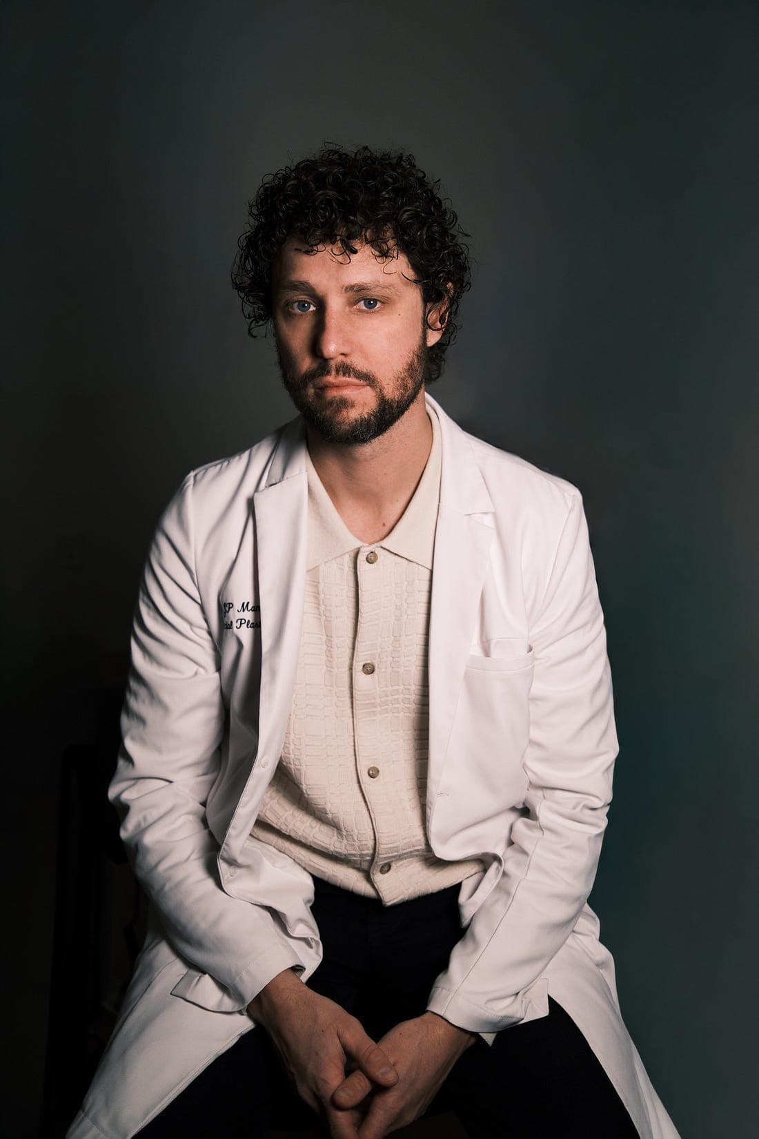 Studio portrait of Dr. James Manning in a white coat, seated against a dark backdrop.